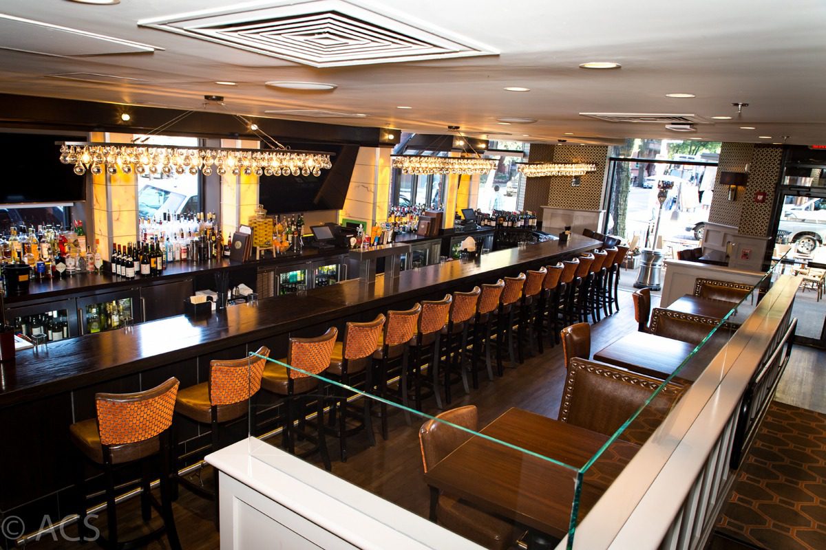 Cozy, stylish bar with wooden stools and warm lighting.