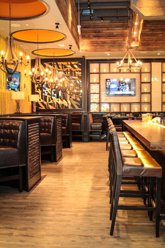 Cozy restaurant interior with wooden decor and leather seating.