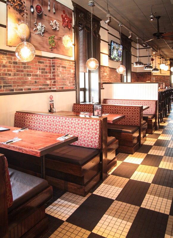 Cozy restaurant booths with brick walls and warm lighting.