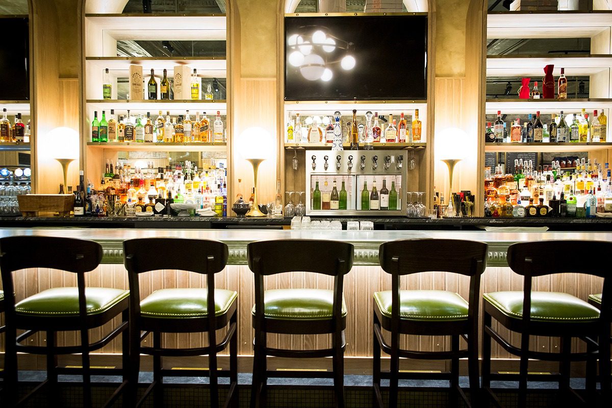 Cozy bar with wooden chairs and a well-stocked liquor display.