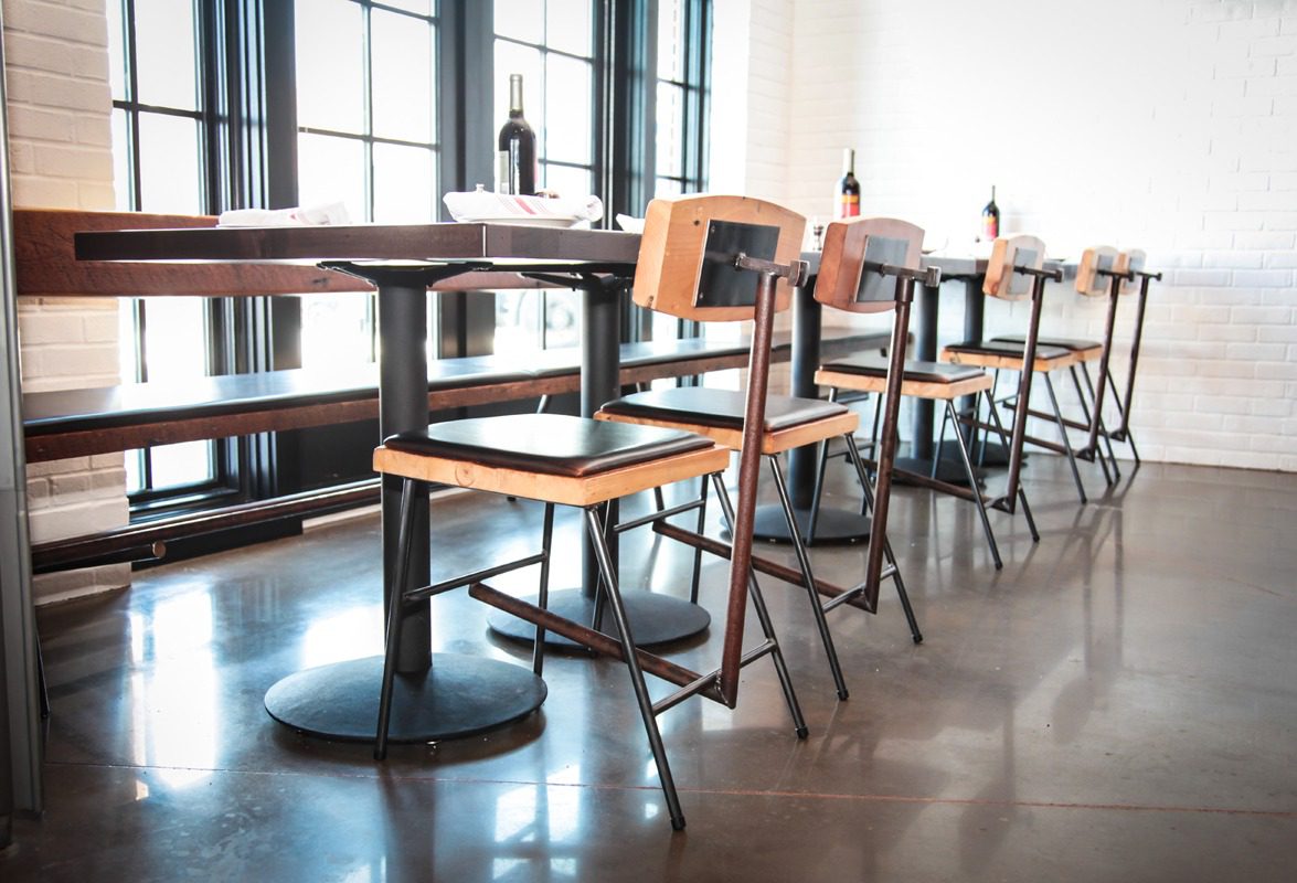 Empty wooden chairs and tables in a bright cafe interior.